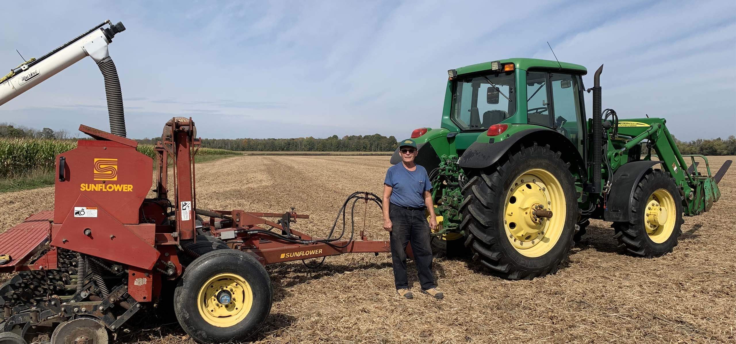 Harvex employee posting by agricultural equipment